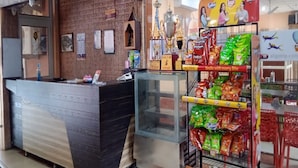 A reception area with a counter, trophies, and a snack display. - Hotel Chakasha Govindam (Devaprayag)