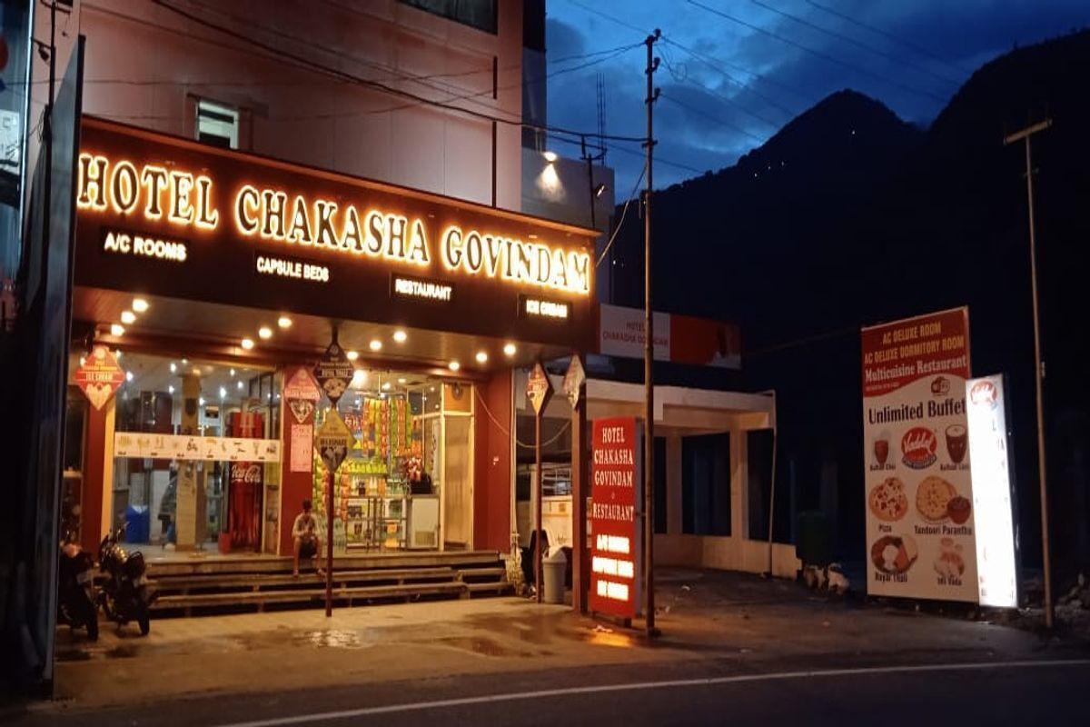 Hotel Chakasha Govindam con habitaciones con aire acondicionado y camas tipo cápsula, un restaurante y un letrero que anuncia buffet ilimitado.