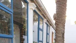 Un bâtiment doté de fenêtres à cadre bleu et d’un pilier en pierre.