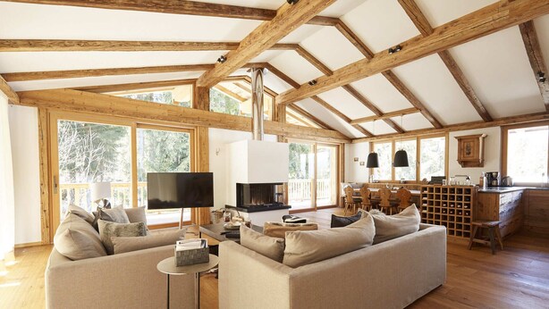 A spacious living room with a large sofa set, a television, and a fireplace.