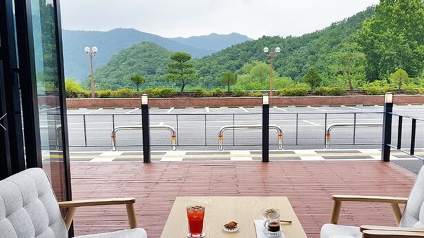 A restaurant with a view of a parking lot and mountains. - Daedunsan Hotel (Wanju)