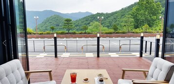 Un restaurante con vista a un estacionamiento y montañas.