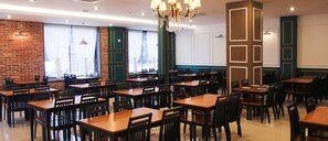 A restaurant with multiple tables and chairs, brick walls, and a chandelier. - Daedunsan Hotel (Wanju)