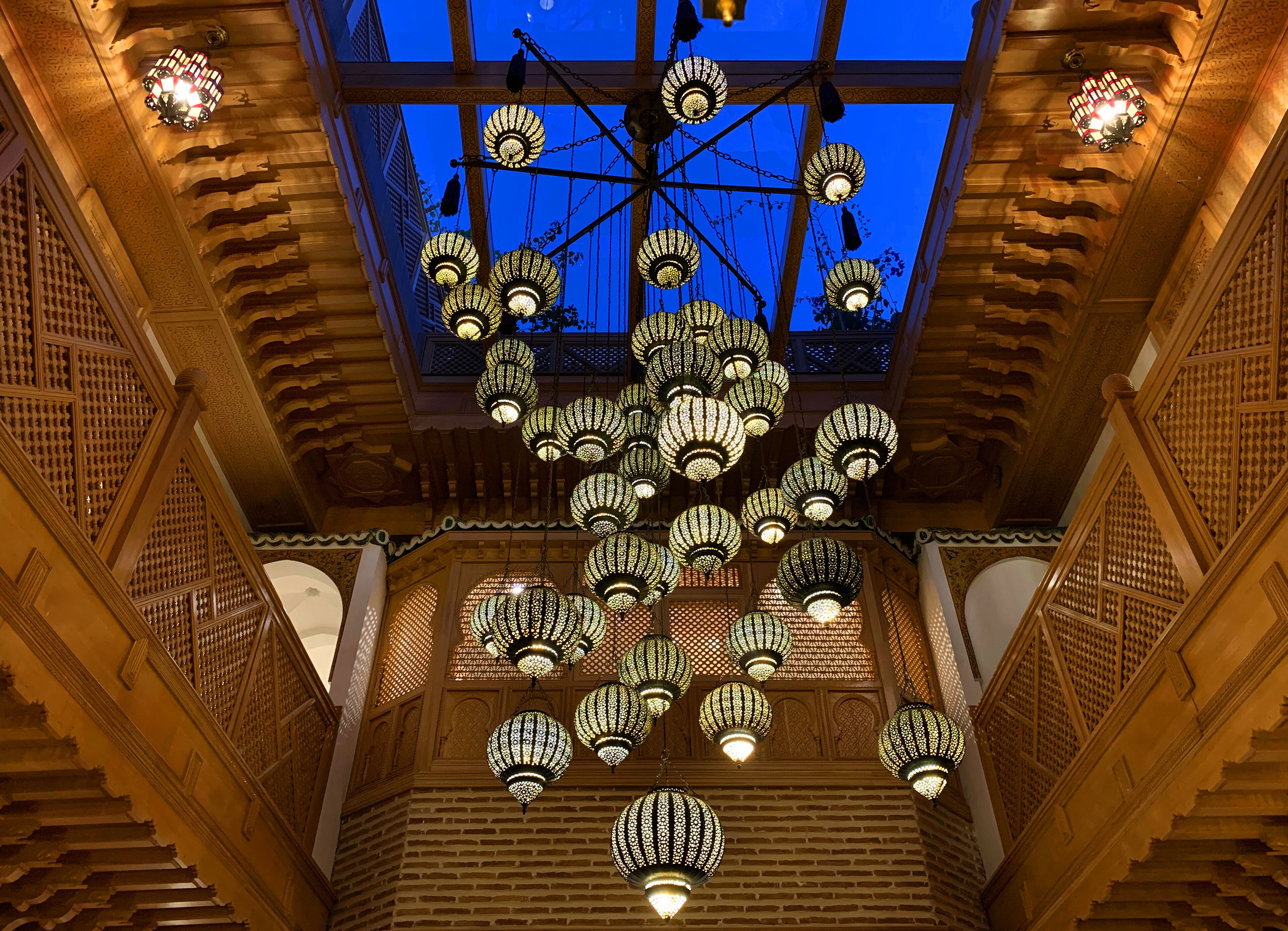 Un intérieur somptueux, caractérisé par une architecture en bois richement décorée, un plafond haut et de nombreuses lanternes suspendues.
