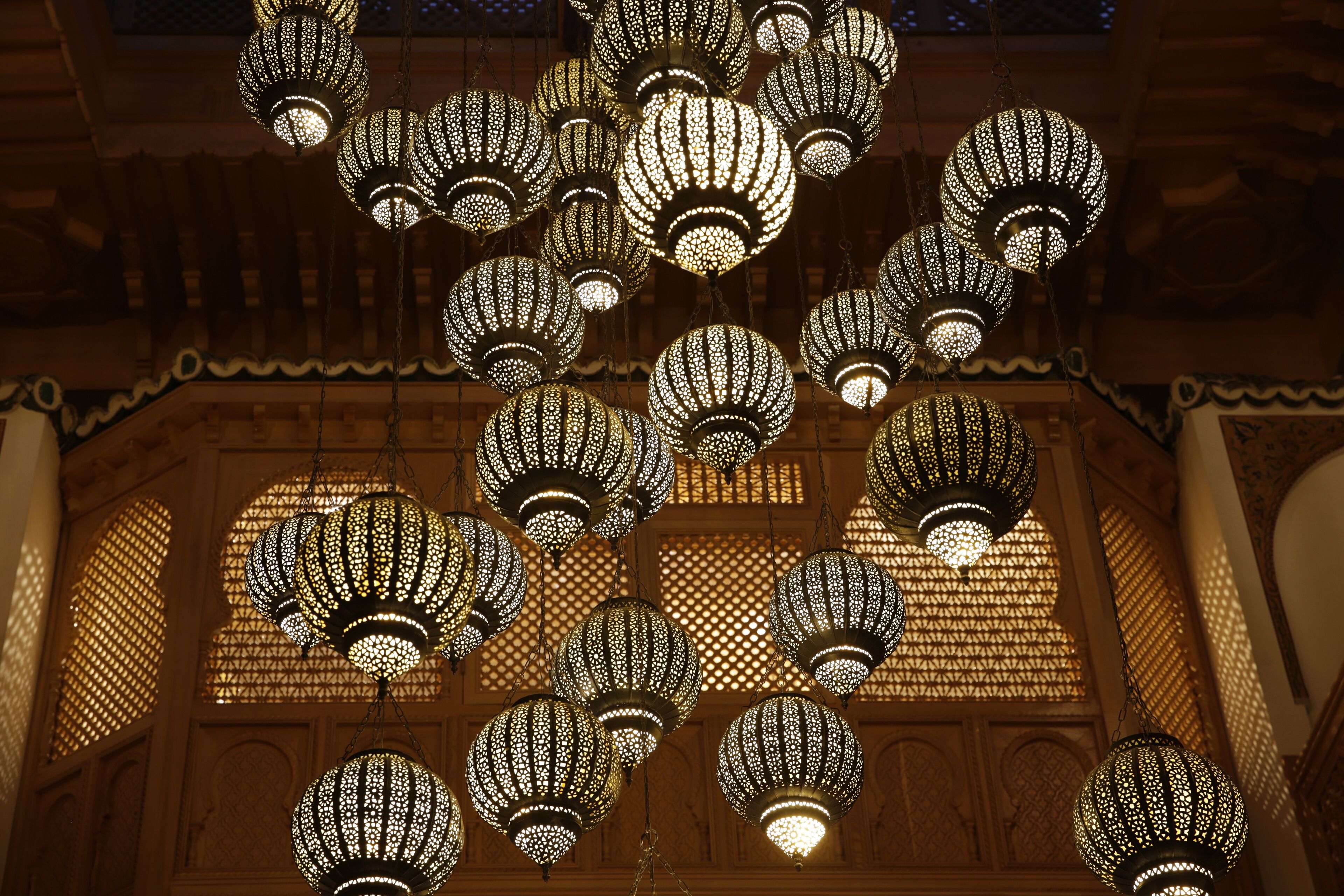 A ceiling with multiple hanging lanterns in a traditional architectural setting.