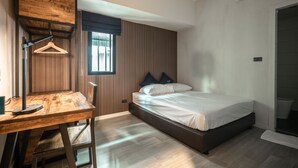 Quarto com cama, escrivaninha e luminária pendente.
