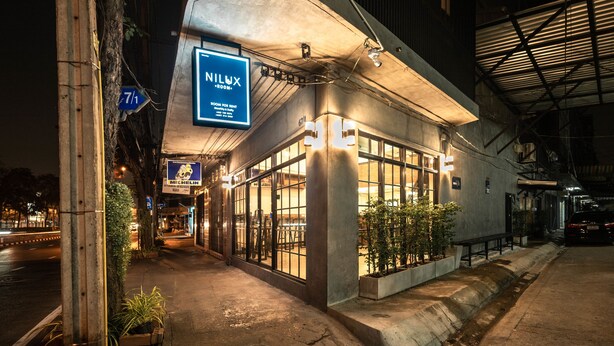 Um edifício com uma placa indicando 'NILUX', mostrando um quarto para alugar.