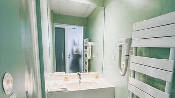 A small bathroom with a sink, mirror, and towel rack.