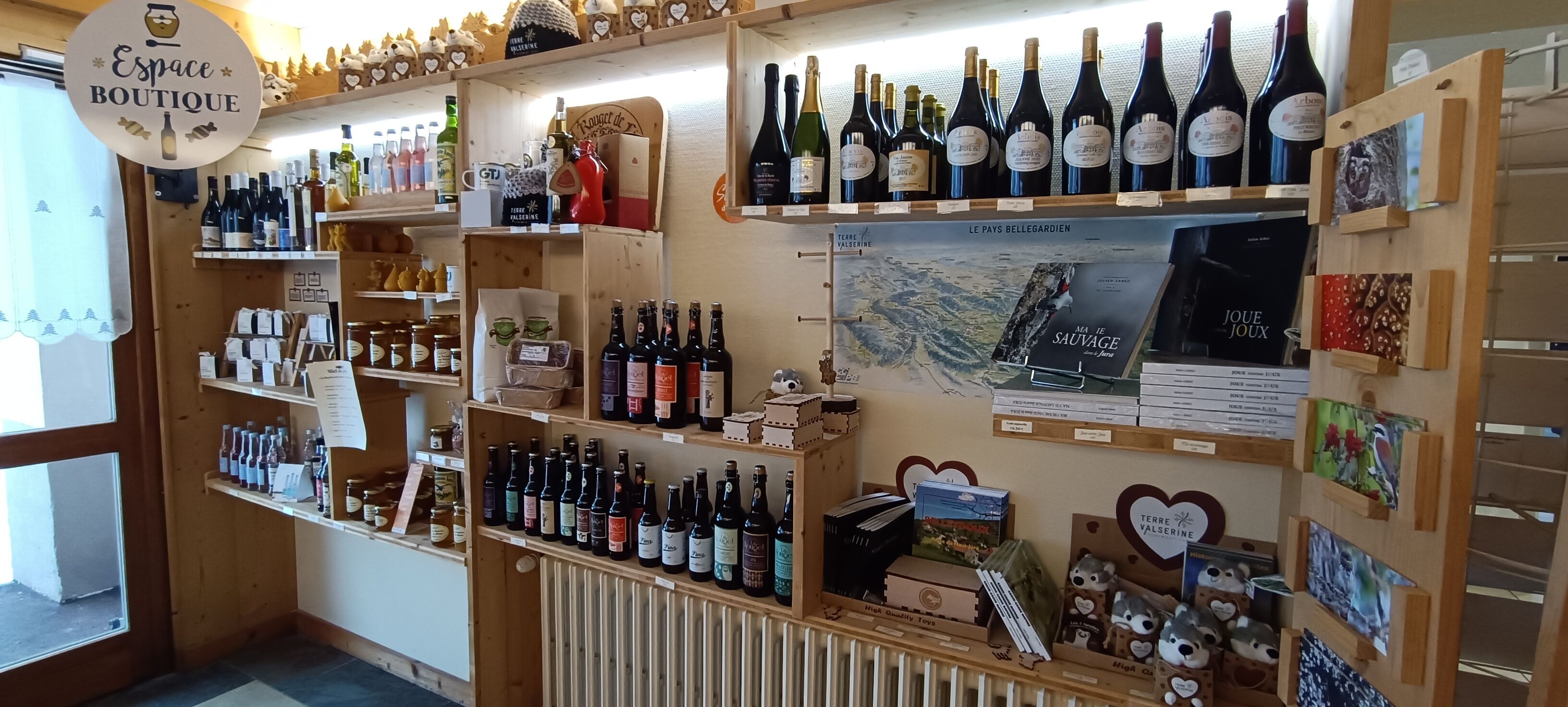 A boutique store with shelves of wine bottles, a map, and various souvenirs.