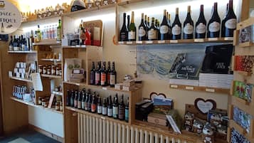 A boutique store with shelves of wine bottles, a map, and various souvenirs.