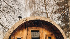 Una cabaña de madera con forma circular, una puerta y dos ventanas.