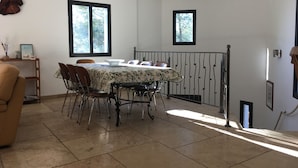 A dining area with a table set for four, surrounded by chairs, with two windows providing natural light. - CONTEMPORARY VILLA IN PROVENCE CAMPAIGN, AIX EN PROVENCE, AUBAGNE, MARSEILL (Peypin)