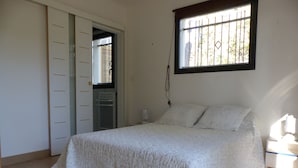 A bedroom with a bed, a wardrobe, a window, and a bedside table. - CONTEMPORARY VILLA IN PROVENCE CAMPAIGN, AIX EN PROVENCE, AUBAGNE, MARSEILL (Peypin)