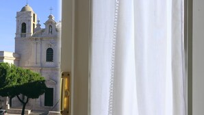 Vista de un edificio blanco con un campanario y una puerta con picaporte de latón.