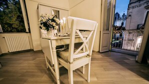 Un comedor con una mesa y silla blancos, un jarrón de flores y velas.