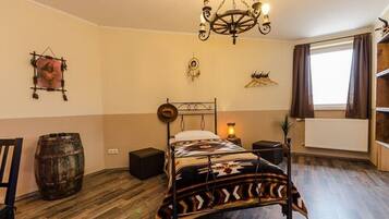 Un dormitorio con cama, una araña, un barril de madera y un radiador.