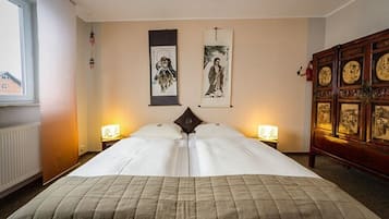 Una habitación de hotel con una cama grande, dos lámparas de noche y obras de arte en las paredes.