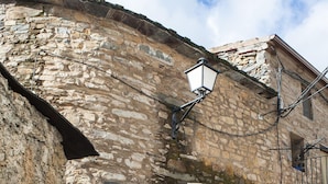 Ein Steinhaus mit einer Holztür, einem Blumentopf und einem Schild mit der Aufschrift 'Corte di Cantegril'.