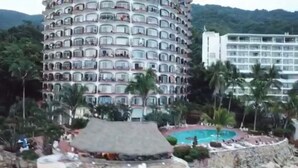 Un hôtel à plusieurs étages doté de balcons, d’une piscine et d’un aménagement paysager de style tropical.