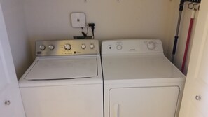 Ein Waschraum mit zwei weißen Waschmaschinen mit Frontlader und einem Trockner.