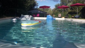 A swimming pool with inflatable toys, umbrellas, and lounge chairs. - Chalet with terrace in the countryside, ideal quiet location. (Tauriers)