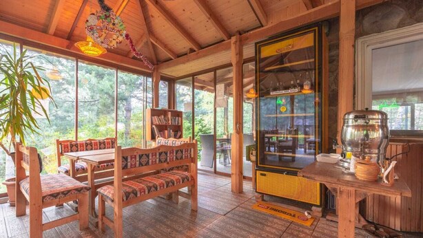 Un interno in legno con un tavolo e panche, una libreria e una macchina per il caffè.