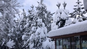 Paesaggio innevato con un edificio dalle ampie finestre e dal tetto coperto di neve.