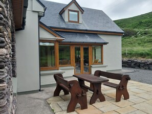 A stone-clad building with a grey exterior, a pitched roof, and a wooden-framed window. - 5* holiday home overlooking Lough Currane Free Wifi Near Hogs Head Golf Course (Waterville)