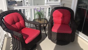 Two wicker chairs with red cushions on a balcony with a view of a residential street. - STEPS TO BEACH & BOARDWALK. 5BR/3BATH. Private Elevator! (Ocean City)
