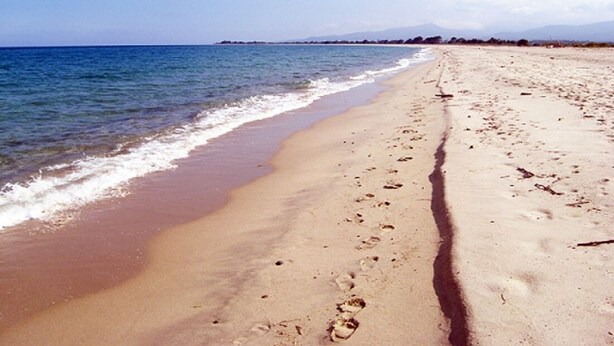 A sandy beach with footprints leading to the water, a clear sky, and distant mountains. - House, pool, haven of peace   (Prunelli-di-Fiumorbo)