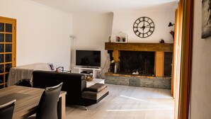 A living room with a fireplace, a television, and a dining area. - House, pool, haven of peace   (Prunelli-di-Fiumorbo)