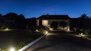 A house with a driveway leading to the entrance, surrounded by greenery and illuminated by street lamps. - House, pool, haven of peace   (Prunelli-di-Fiumorbo)
