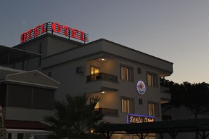 A hotel with a prominent 'OTEL' sign on the roof, a balcony with a railing, and a 'Seren Hotel' sign on the building facade. - Serin Otel (Urla)