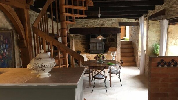 A rustic interior with a wooden staircase, a fireplace, and a dining area with a table and chairs. - Authentic House of charm 4 stars magnificent view on castles (Beynac-Et-Cazenac)