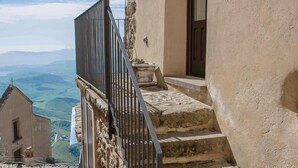 A narrow stone staircase leading to a building with a metal railing. - Case al Borgo - Albergo diffuso (Agira)