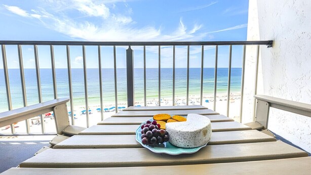 A balcony with a view of the beach and ocean, a plate of cheese and grapes, and a white wall. - Unbelievable Views!! Newly remodeled condo, Beachfront in fantastic location! (Orange Beach)