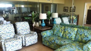 A living room with a sofa, two armchairs, a coffee table, and a lamp. -  Beautiful Ocean Front, Deluxe 2 BR/BA , Free Wifi, Prime Location. (Panama City Beach)