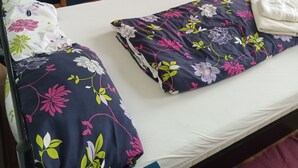 Une chambre à coucher avec un lit, une armoire et une petite table avec une chaise.