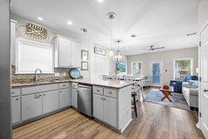 A modern kitchen with granite countertops, white cabinetry, and a central island.