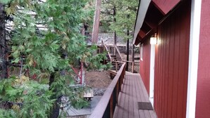 Eine Holzterrasse mit einem roten Gebäude im Hintergrund.