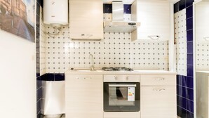 A modern kitchen with a built-in oven, a gas stove, and a water heater. - Chia Deluxe (Naples)