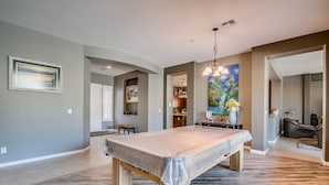 Una habitación amplia con una cama grande, una mesa de comedor y una cocina visible a través de un umbral abierto.