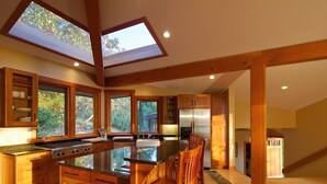 Una cocina amplia con una isla grande, armarios de madera y tragaluces.