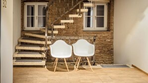 A staircase leading to a second floor, two white chairs in the foreground, and a number '32' on the wall. - OX Hotel Café Bar Restaurant (Heitersheim)
