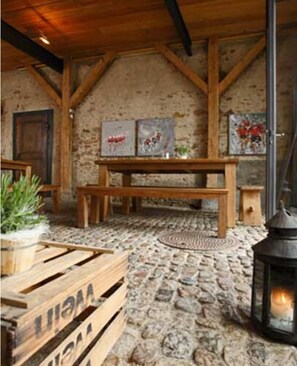 A rustic interior with a stone floor, wooden beams, a bench, and a lantern. - OX Hotel Café Bar Restaurant (Heitersheim)