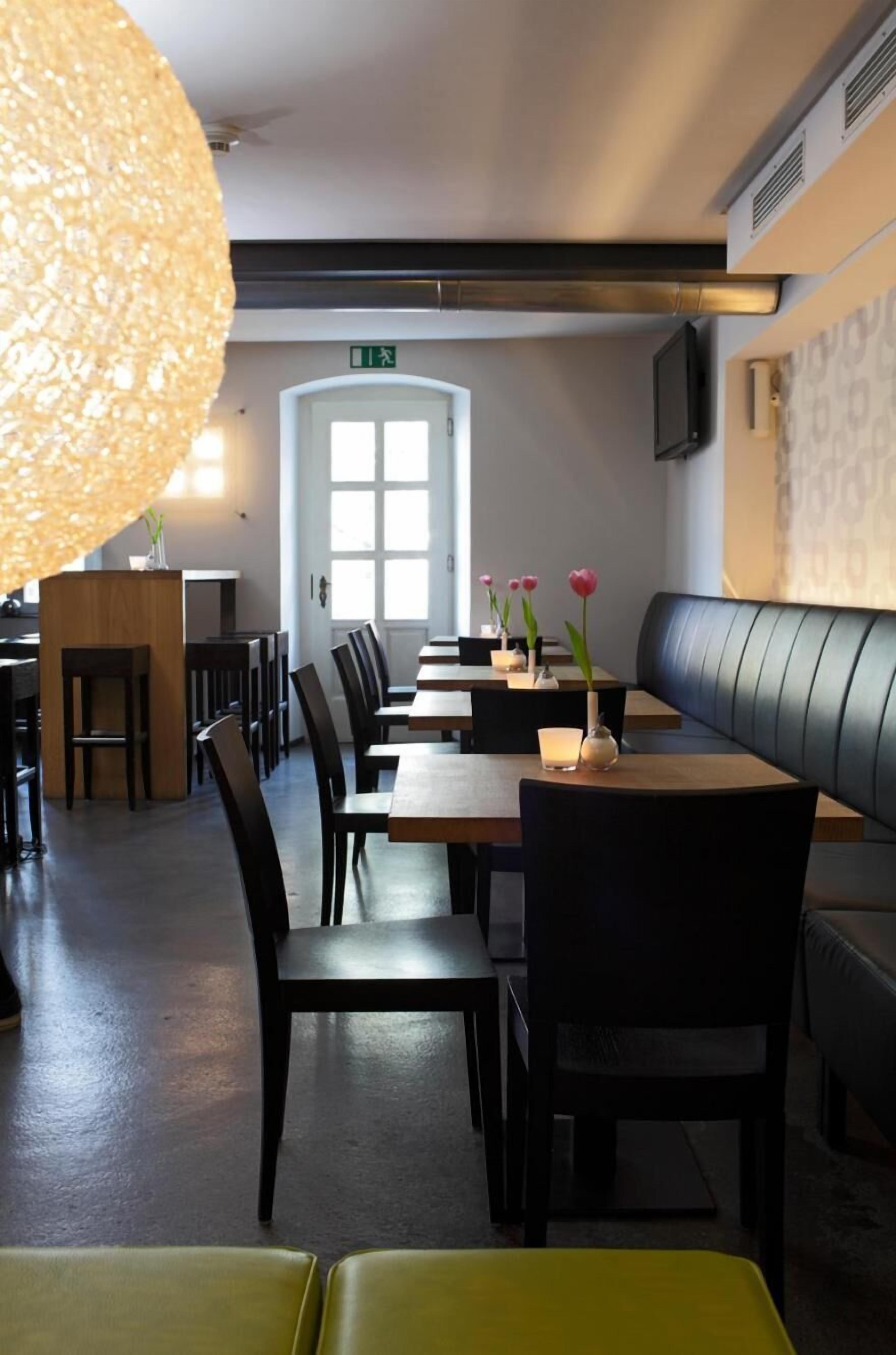 A restaurant with a long table, chairs, and a booth area.