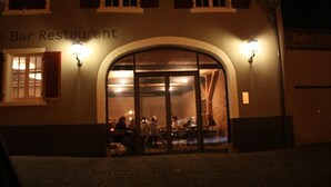 A bar restaurant with an arched entrance and two wall-mounted lights. - OX Hotel Café Bar Restaurant (Heitersheim)