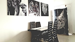 A dining area with a table and chairs, and three framed animal portraits on the wall. - Appartement Maképé B.M 2 (Douala)