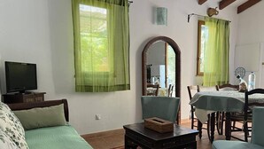 A room with a bed, a table, a chair, a mirror, and a television. - Apartment on wooded land 2 minutes from the beaches and the center (Propriano)