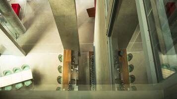 Una habitación con techo de concreto, una mesa de madera y un separador de vidrio.